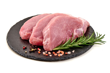 Raw pork steaks on slate plate, isolated on white background