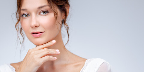 Elegant Woman With Soft Smile Touching Chin in White Lace Dress