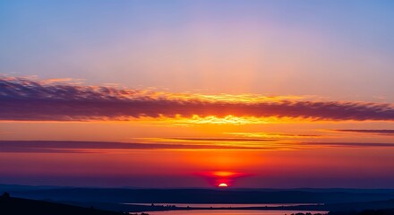 Fototapeta premium Vibrant sunset with dramatic sky over water creating a beautiful landscape