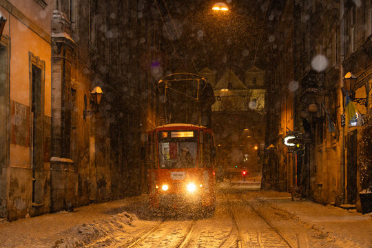 Red Tram Navigating Snowy Ruska Street in Night Lviv