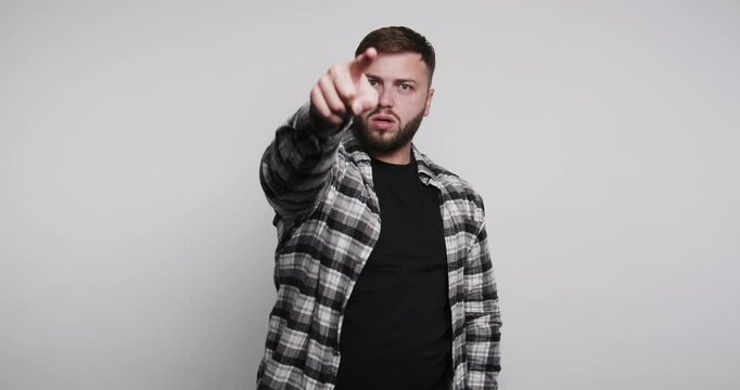 Man points at the camera with an assertive expression during a portrait session in a studio