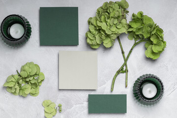 Greeting card, message, invitation, or menu with hydrangea branches in green tones and candles.