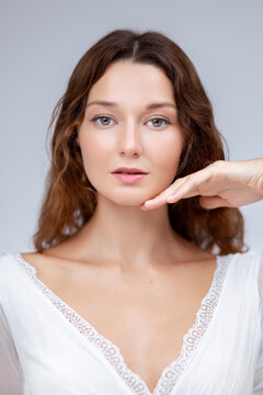 Confident Woman in White Dress Posing With Hand Under Chin