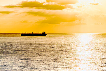 Cargo ships sailing at sunset, towards the port of Barcelona
