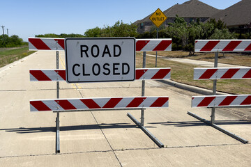 Traffic barricade with way closed sign on quiet residential road