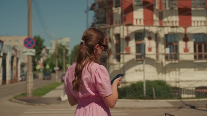 streetside observation caucasian woman gazing building, historic facade under renovation with scaffolding, architectural detail study, pink dress contrast, reflective mood, summer afternoon, quiet