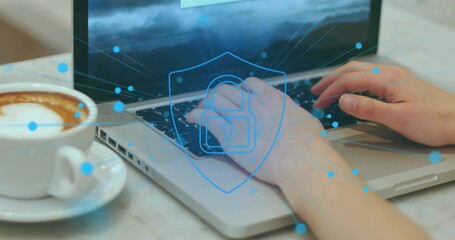 Typing user's hands entering data on silver laptop at marble table, with latte and security overlay