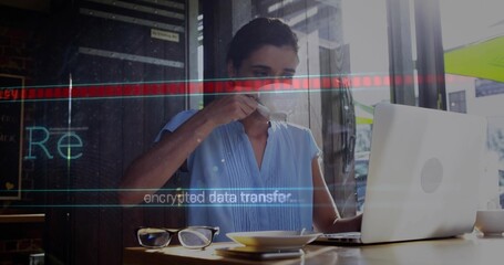 Sipping woman wearing light-blue blouse typing on laptop at cafe table, with encrypted overlay