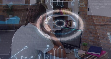 Working man with glasses wearing grey t-shirt typing on laptop at home office, HUD overlay