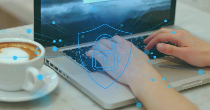 Typing user's hands entering data on silver laptop at marble table, with latte and security overlay
