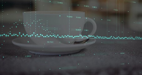 Displaying white ceramic teacup and saucer with teaspoon at cafe table, teal data overlay