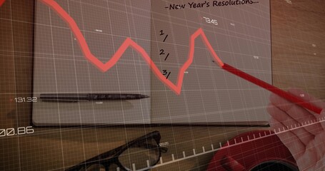 Sketching right-hand in red sleeve using red pencil on open notebook on desk with data overlay