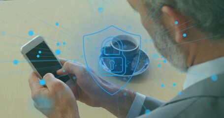 Tapping phone, businessman wearing gray suit at light wood table, coffee cup and security overlay