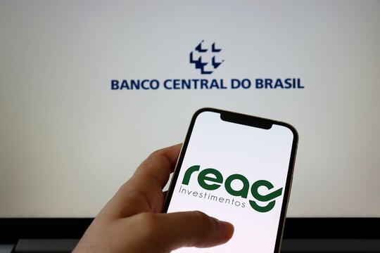 REAG Investimentos logo and Banco Central do Brasil logo on  smartphone screen. Reag logo.
