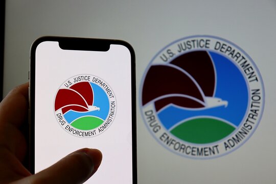 The Drug Enforcement Administration (DEA) logo displayed on a smartphone screen. USA DEA logo. US Justice Department. 