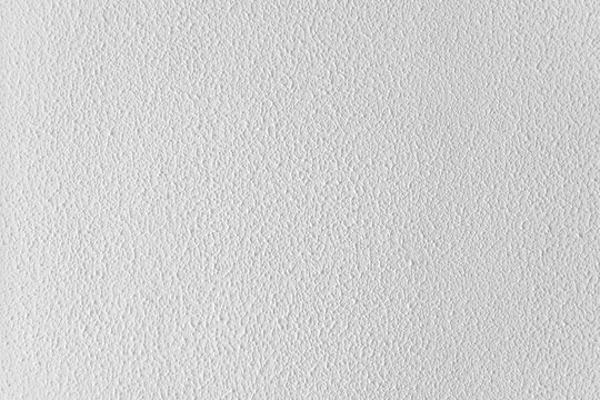 Primer plano de pared blanca de estuco o yeso con textura irregular, hendiduras y acabado mate.Primer plano de pared blanca de estuco o yeso con textura irregular, hendiduras y acabado mate.
