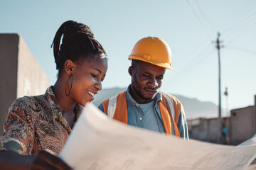 Two construction professionals review blueprints outdoors, showcasing collaboration and planning in a vibrant, sunny setting.
