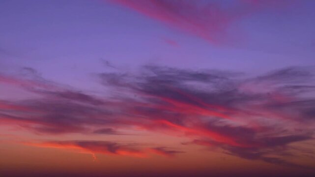 Bright multicolored sunset sky sun and light feathery clouds fast time lapse horizon. Sun beautiful sky and cirrus clouds changing colors time-lapsed, amazing colorful skyscraper.