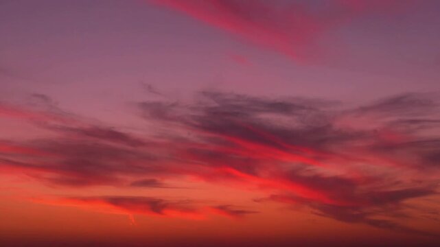 Fantasy multi colored sunset sky sun and and feathery clouds multi colors fast time lapse horizon. Sun beautiful evening sky and cirrus clouds time-lapsed, colorful skyscraper background.