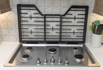 Modern gas cooktop installed in a kitchen with a stylish backsplash and multiple burners for cooking meals