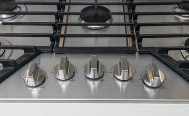 Detail of controls on gas cooktop installed in a kitchen with multiple burners for cooking meals