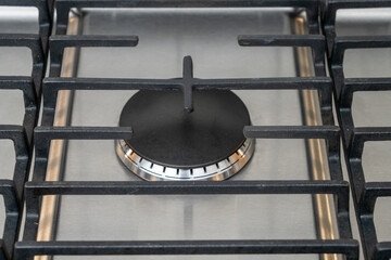 Detail of single modern gas cooktop or gas hob burner and grate