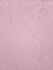 Fototapeta premium Title: A textured, pink abstract space. The light pink walls, with their rough stone texture, create a modern and sensual atmosphere.