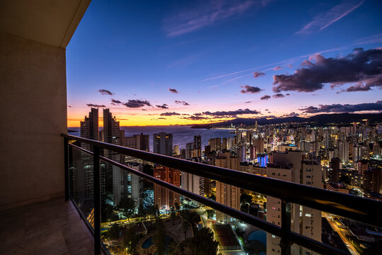 benidorm spain mediterranean balcony terrace overlooking skyline cityscape at twilight as lights appear along the horizon above the sea