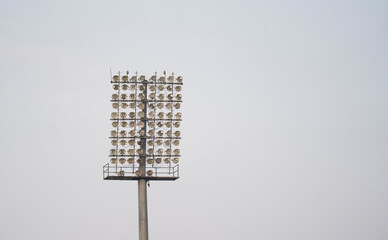 A floodlight tower stands against a clear sky at a sports ground in Guwahati, Assam, India, featuring multiple high-intensity lights mounted on a tall metal mast