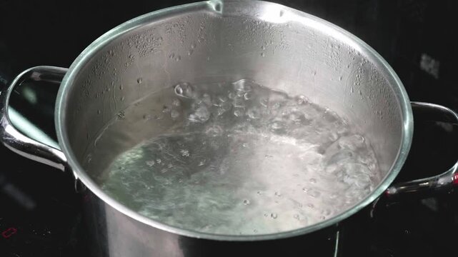 Water dances and froths in a metal pot. Heat rises as bubbles form and pop during the day, creating a mesmerizing spectacle of physics in culinary motion