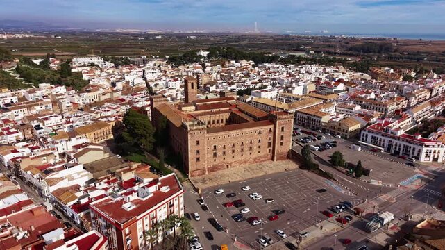 Smooth orbit aerial view of El Puig de Santa Maria, highlighting the historic monastery, dense residential blocks and surrounding Valencian landscape