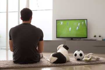 Obraz na płótnie Canvas Quiet Moment Inside Living Room Watching Soccer Match with Dog Companion