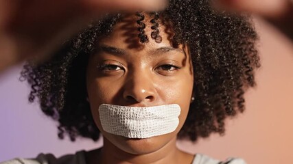 Silenced Woman with Tape on Mouth Looking at Camera, Censorship and Human Rights Concept
