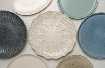 Empty ceramic round and oval plates on white background, pattern