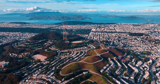 Vast urban landscape of modern San Francisco, California, USA. Drone footage around the green hills with Sutro Tower on.