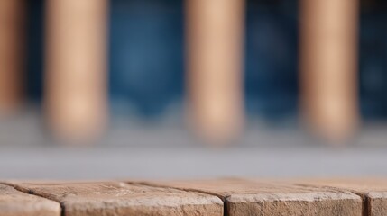 A close-up view of wooden planks with blurred columns in the background, suggesting a serene outdoor setting.