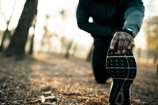 Athlete stretching before run in forest park