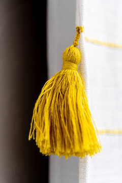 Yellow Decorative Tassel Detail on White Curtain Close-Up