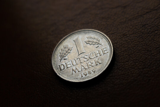 one old shiny silver colored deutschmark coin laying on a wooden underground