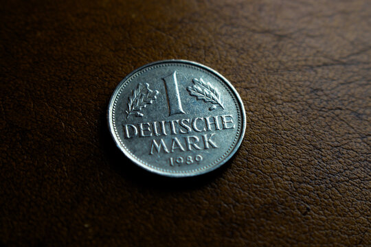 one old shiny silver colored deutschmark coin laying on a wooden underground