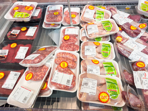 Tarvisio, Italy - January 15, 2026: Various packaged meats displayed in a supermarket refrigerator, featuring labels and price tags on trays of beef, pork, and chicken products