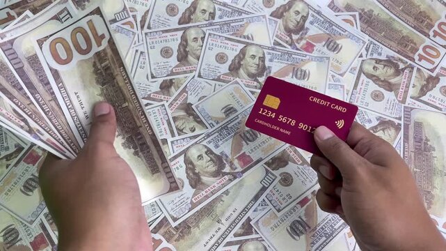 A close-up view of a hand holding a credit card and a dollar bill. An illustration of finance and business using dollars.