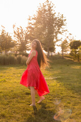 beautiful teenage brunette girl with long hair, smiling, looking at the camera during a summer walk