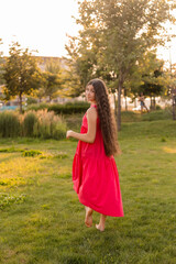 beautiful teenage brunette girl with long hair, smiling, looking at the camera during a summer walk