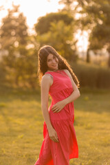 beautiful teenage brunette girl with long hair, smiling, looking at the camera during a summer walk