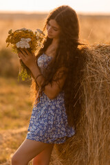 beautiful teenage brunette girl with long hair, smiling, looking at the camera during a summer walk
