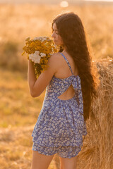 beautiful teenage brunette girl with long hair, smiling, looking at the camera during a summer walk