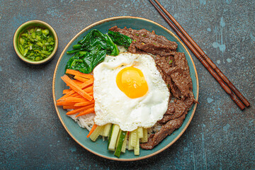 Traditional korean dish bibimbap with fried egg on top, top view