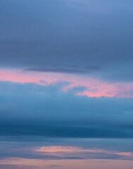 Dense blue grey clouds with a soft pink sunset streak