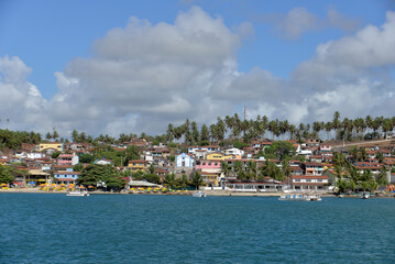 Fototapeta premium panoramic view of barra do cunhaú village from the river, scenic coastal town landscape in rio grande do norte brazil, tropical riverside village with coconut trees and blue water, summer travel desti